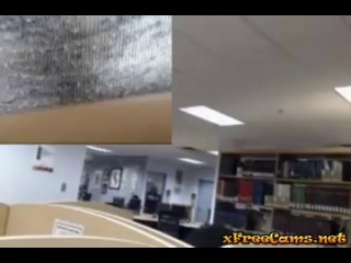 a girl masturbates with a dildo in front of a webcam installed in a public hall.